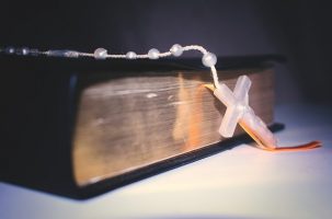 Black bible with white Rosary