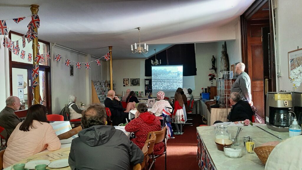 St Peter's community room takes on a 1940s feel with a film show, bunting and people in in 1940s costume watching the film