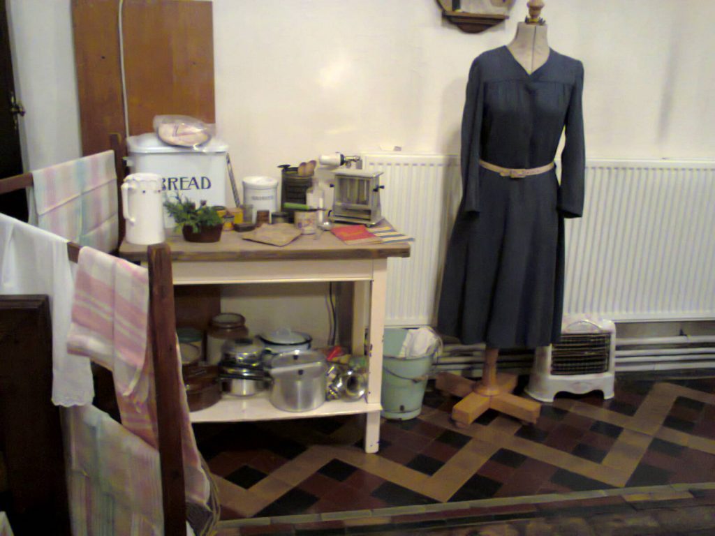 Home Front isplay in church of a 1940s dress and kitchen table with lots of pots and pans