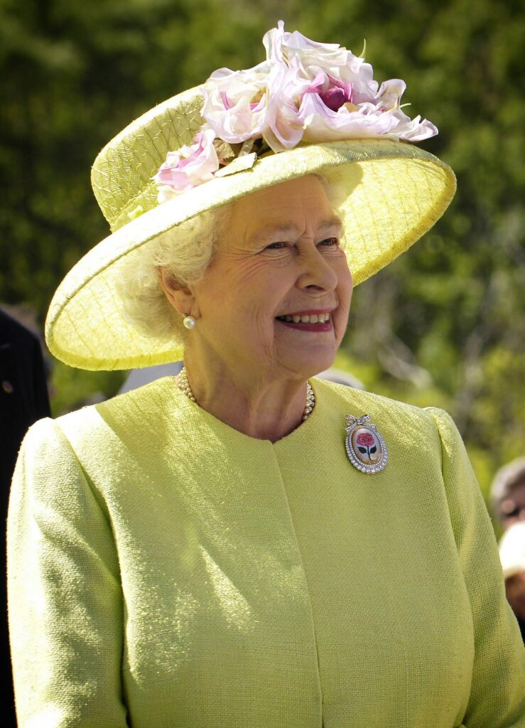 Queen Elizabeth II - head and shoulders portrait of Her Majesty smiling dressed in yellow in the sunshine