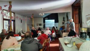 St Peter's community room takes on a 1940s feel with a film show, bunting and people in in 1940s costume watching the film